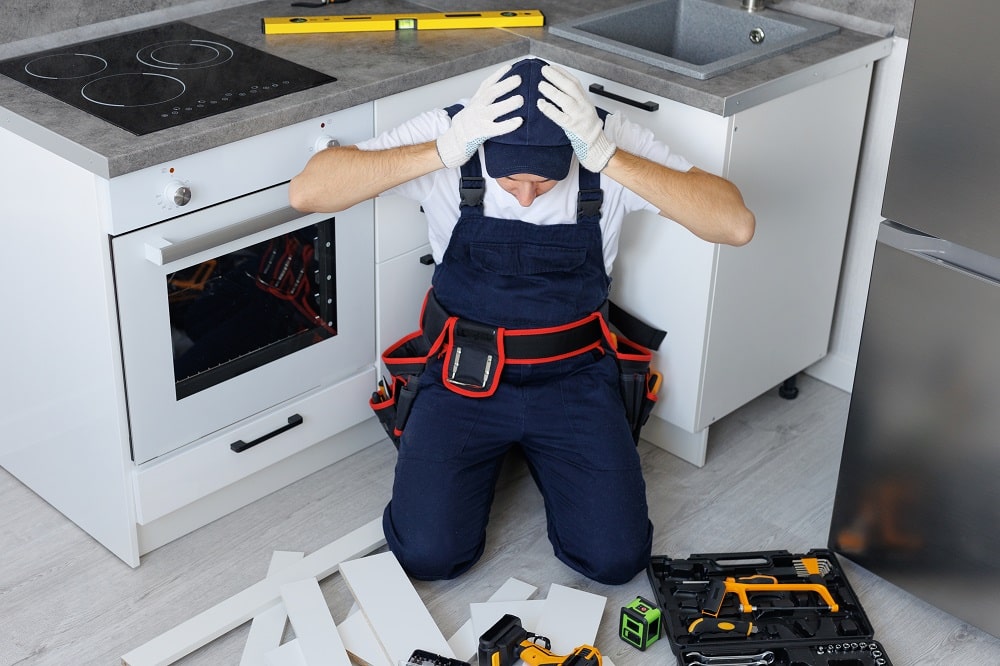 Man in uniform looks at the disassembled furniture and accessories and holds his head
