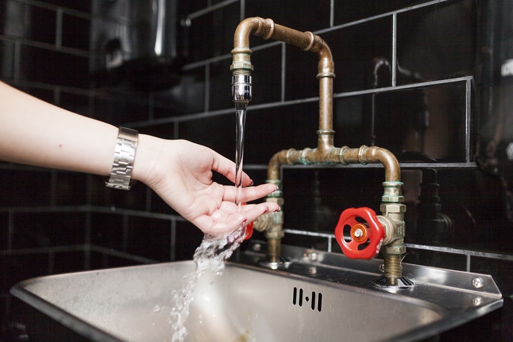 woman washing hands in sink