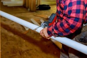 Cutting plastic pipe by special red scissors. 