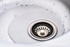 Close-up stainless steel sink with water splashes.