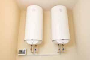 Two electric water heaters on the wall. Home wall mounted two water heating boilers. No people.