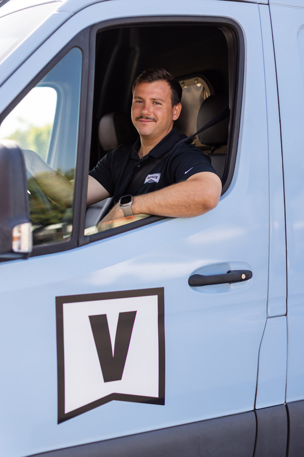 Technician in driver seat of Voyager Plumbing service car